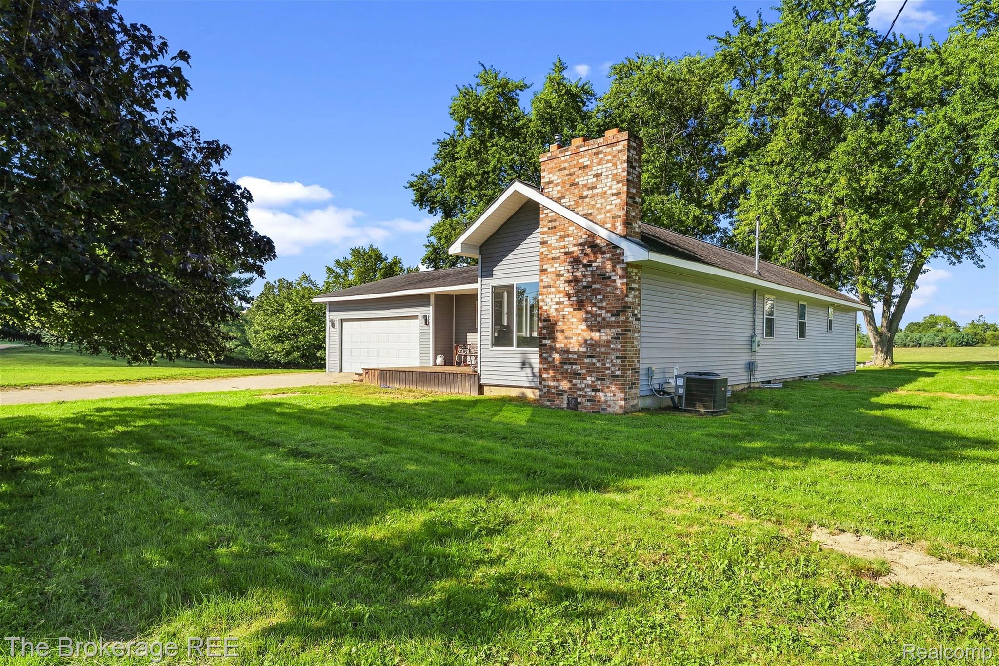 4443 North Gale Road Davison, MI 48423 - Photo 2 of 36 Exterior featuring brick chimney, gray siding, attached garage, and a wood-finish porch