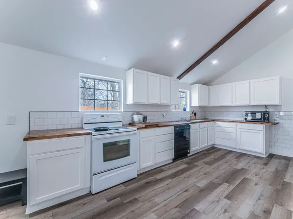 a kitchen with a stove top oven and white cabinets