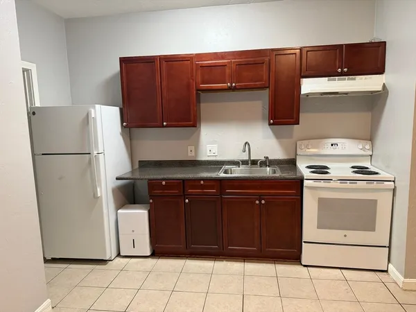 a kitchen with a refrigerator and a stove