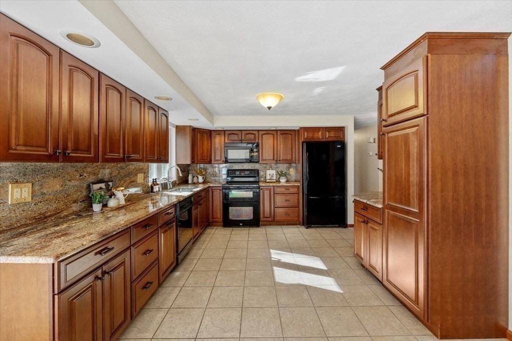 107 Ash Street Rehoboth, MA 02769 - Photo 9 of 34 a kitchen with stainless steel appliances granite countertop a refrigerator and a stove top oven