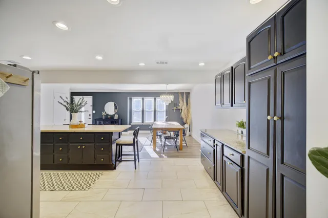 a large kitchen with stainless steel appliances granite countertop a refrigerator and a sink