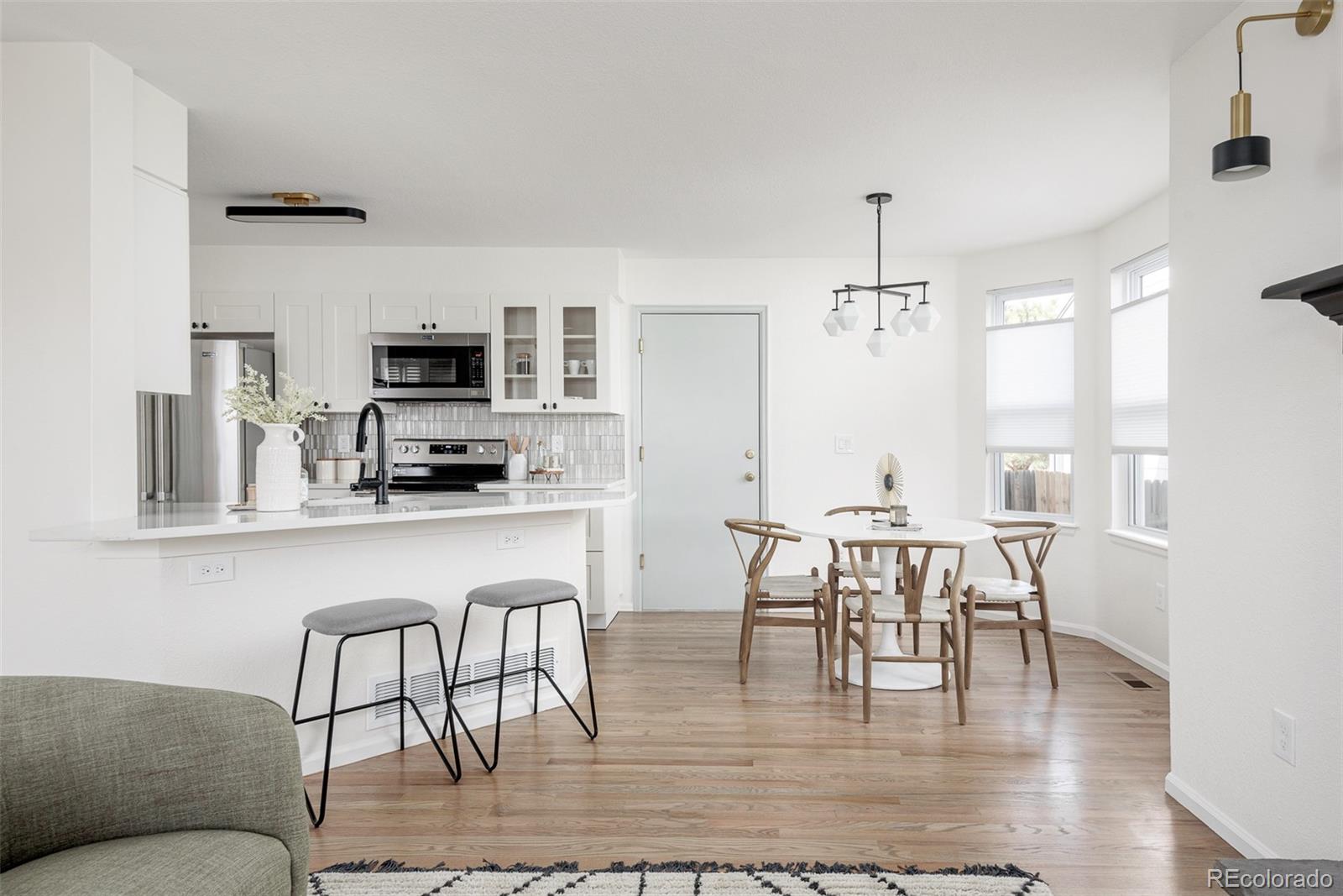 10754 West 107th Circle Westminster, CO 80021 - Photo 11 of 24 a kitchen with a dining table chairs and granite kitchen island