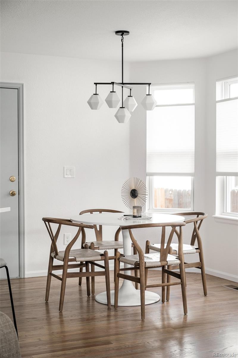10754 West 107th Circle Westminster, CO 80021 - Photo 13 of 24 a view of a dining room with furniture and wooden floor