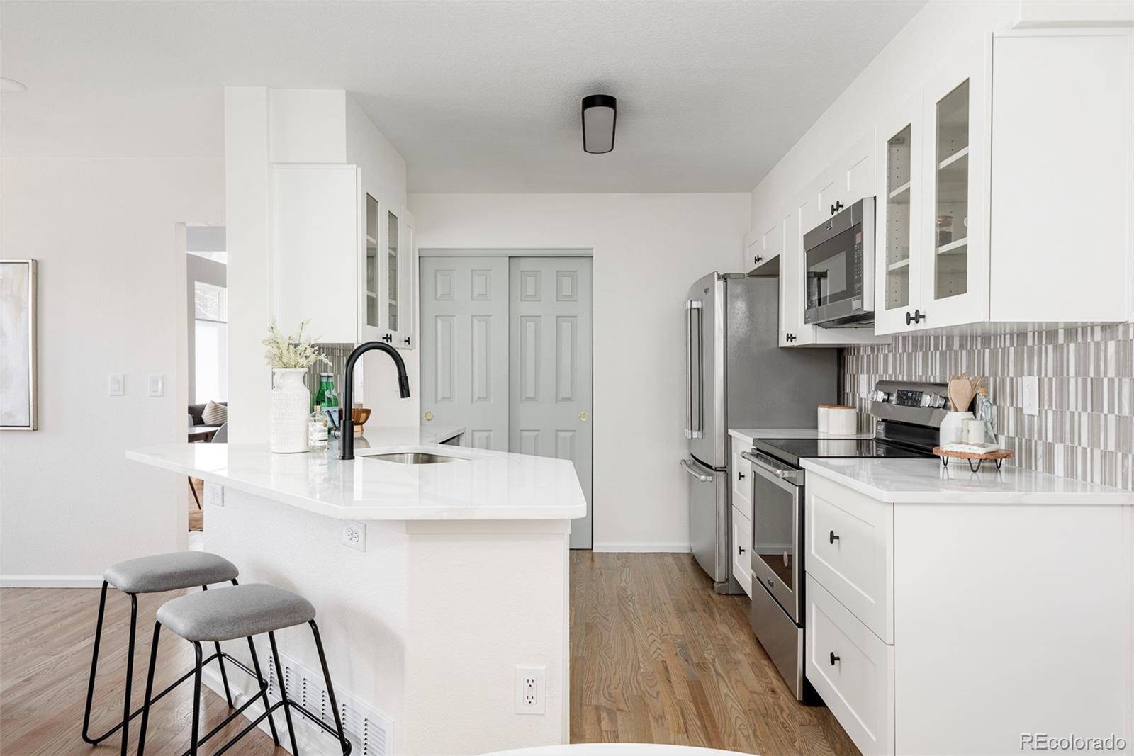 10754 West 107th Circle Westminster, CO 80021 - Photo 14 of 24 a kitchen with stainless steel appliances granite countertop a sink stove and refrigerator
