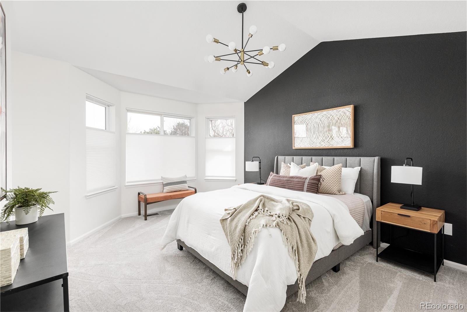 10754 West 107th Circle Westminster, CO 80021 - Photo 16 of 24 a bedroom with a bed and a chandelier