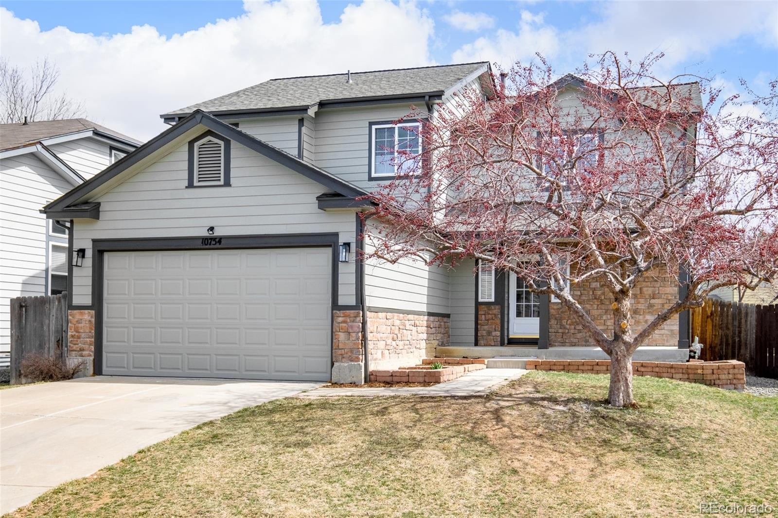 10754 West 107th Circle Westminster, CO 80021 - Photo 2 of 24 a house that has a tree in front of the house