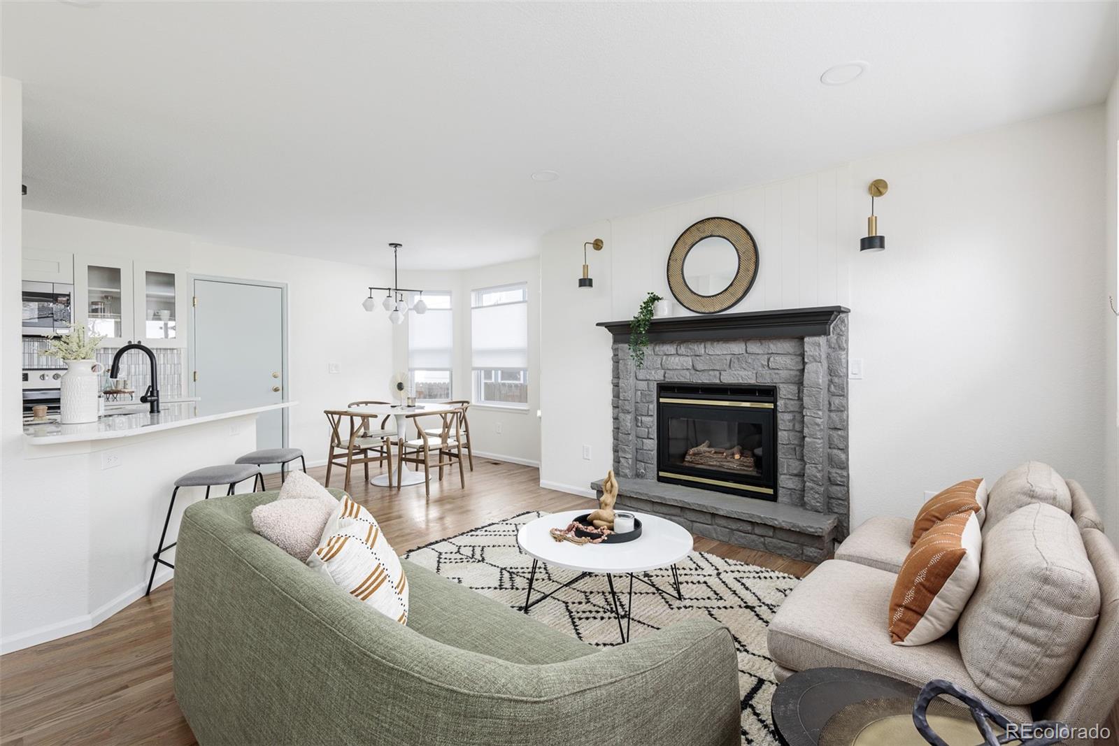 10754 West 107th Circle Westminster, CO 80021 - Photo 10 of 24 a living room with furniture a fireplace and a table