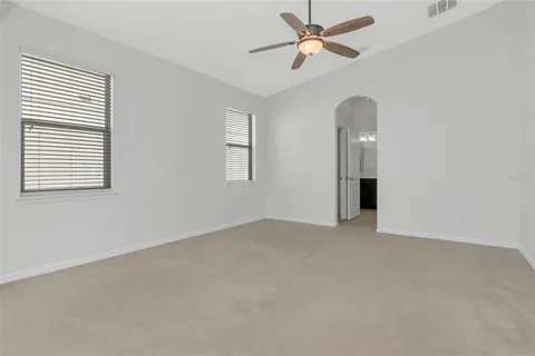 an empty room with windows and fan