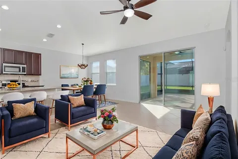 a living room with furniture and a view of kitchen