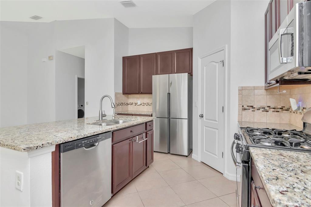 11229 Spring Point Circle Riverview, FL 33579 - Photo 7 of 40 a kitchen with stainless steel appliances granite countertop a refrigerator stove and sink