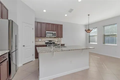 a kitchen with stainless steel appliances granite countertop a sink a refrigerator and a granite counter tops