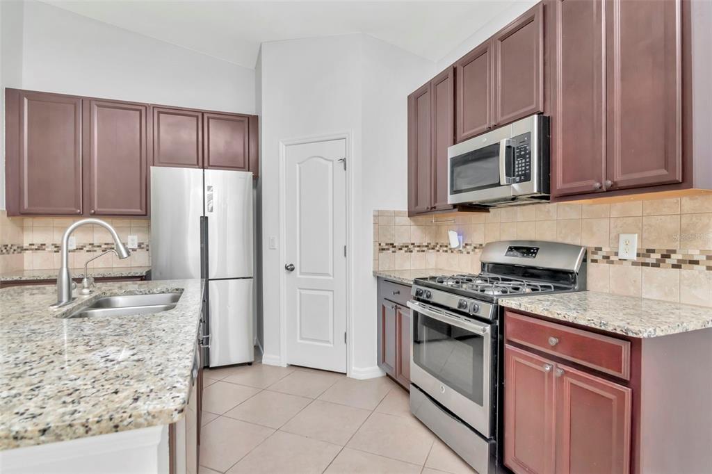 11229 Spring Point Circle Riverview, FL 33579 - Photo 9 of 40 a kitchen with stainless steel appliances granite countertop a stove microwave and refrigerator
