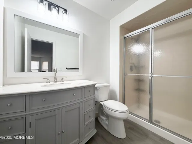 a bathroom with a sink a toilet and shower