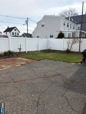 a view of a white house with a yard and garage