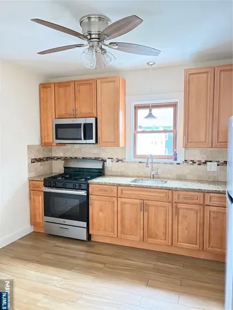 a large kitchen with granite countertop a stove and a sink