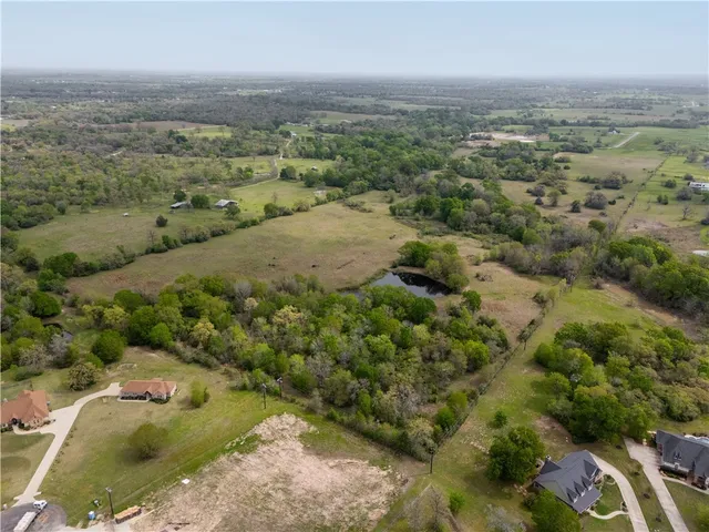 an aerial view of house with yard and mountain view in back