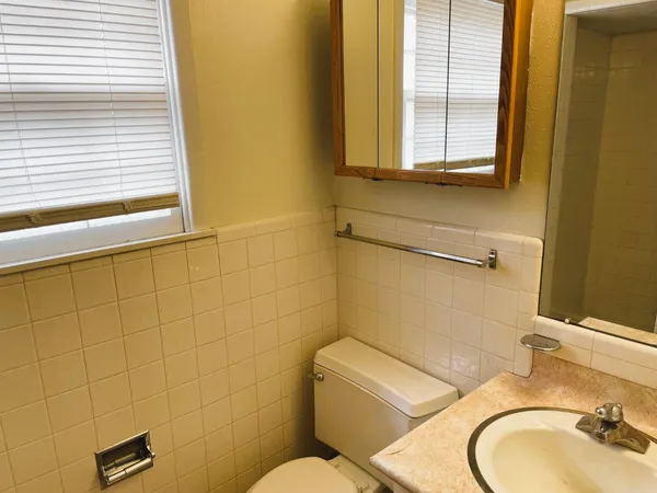 a bathroom with a toilet sink and mirror