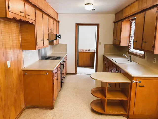 a kitchen with stainless steel appliances granite countertop a sink and a refrigerator