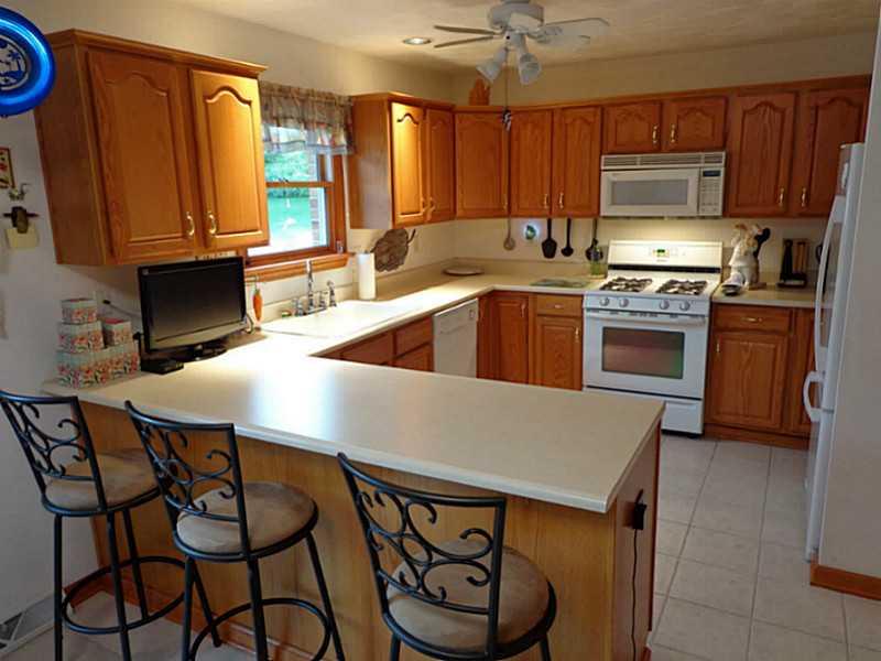 1065 Finchley Road North Huntingdon, PA 15642 - Photo 8 of 25 Kitchen. And a 22 foot long eat in kitchen. It has a breakfast bar and also room for a table. There is a sliding glass door that opens to the deck and swimming pool. Opposite the breakfast bar are large pantry cabinets that match the rest of the kitchen.