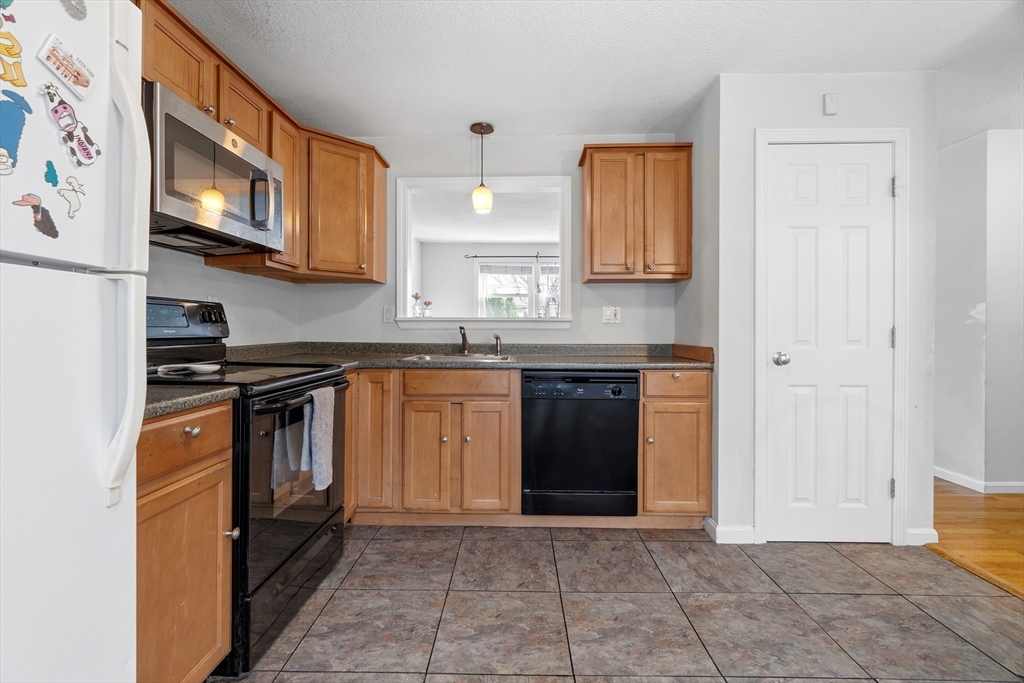 45 Lawn Street Boston, MA 02120 - Photo 4 of 22 a kitchen with stainless steel appliances granite countertop a stove a sink and a refrigerator