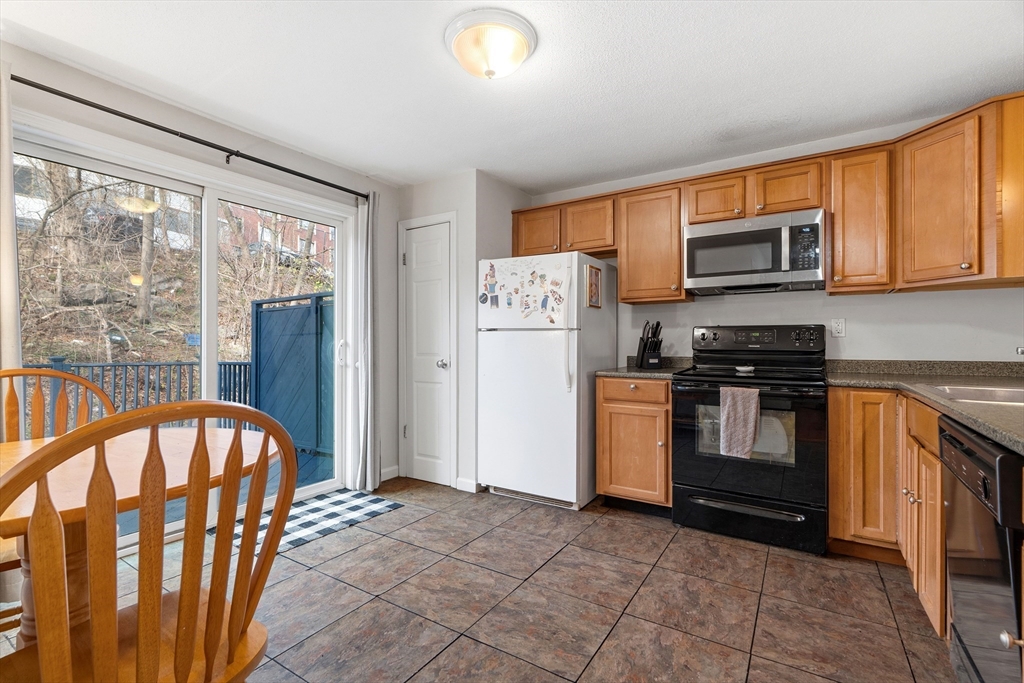45 Lawn Street Boston, MA 02120 - Photo 5 of 22 a kitchen with stainless steel appliances granite countertop a refrigerator a stove top oven a sink and dishwasher
