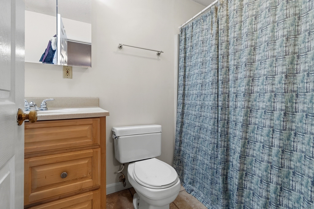 45 Lawn Street Boston, MA 02120 - Photo 9 of 22 a bathroom with a toilet and a shower curtain