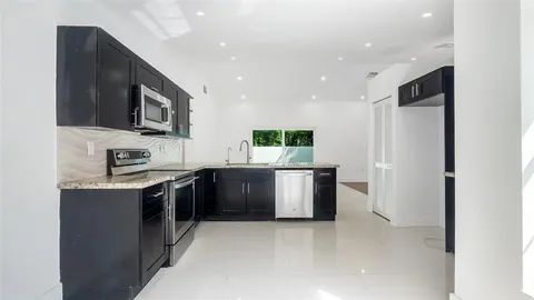 a kitchen with stainless steel appliances granite countertop a refrigerator and a stove top oven