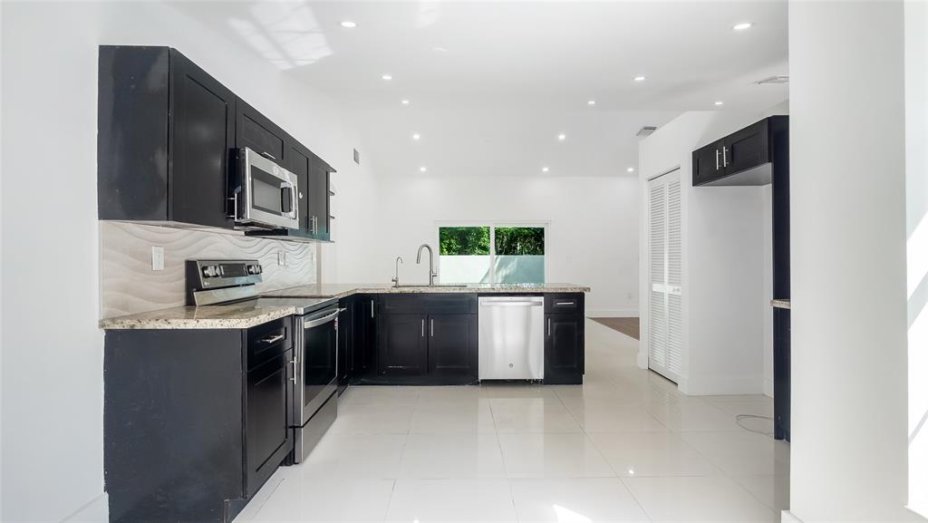 1811 Southwest 124th Way Miramar, FL 33027 - Photo 12 of 29 a kitchen with stainless steel appliances granite countertop a refrigerator and a stove top oven