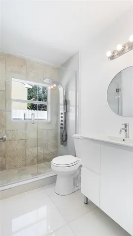 a bathroom with a sink a toilet and shower
