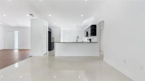 a view of a kitchen with a refrigerator and a stove top oven