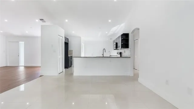 a view of a kitchen with a refrigerator and a stove top oven