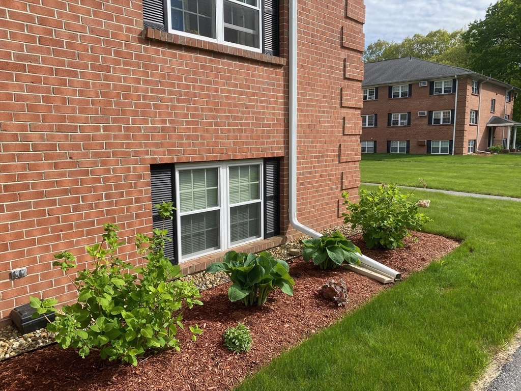 30 Leonard Road, Unit 30 Boxborough, MA 01719 - Photo 24 of 30 a view of a brick house with a yard plants and large trees