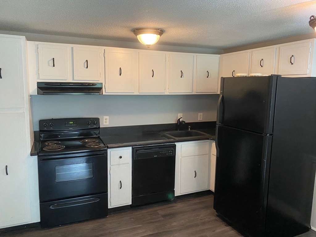 30 Leonard Road, Unit 30 Boxborough, MA 01719 - Photo 5 of 30 a kitchen with granite countertop white cabinets and stainless steel appliances