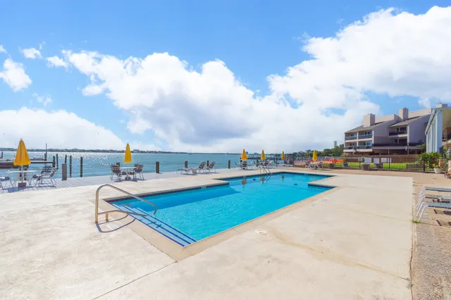 a view of swimming pool with seating area and barbeque oven