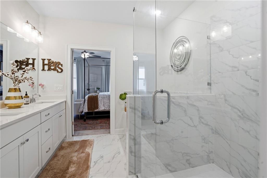 3880 Pr Fld Crossing Suwanee, GA 30024 - Photo 25 of 51 a en suite bathroom with a double vanity sink a mirror and a shower