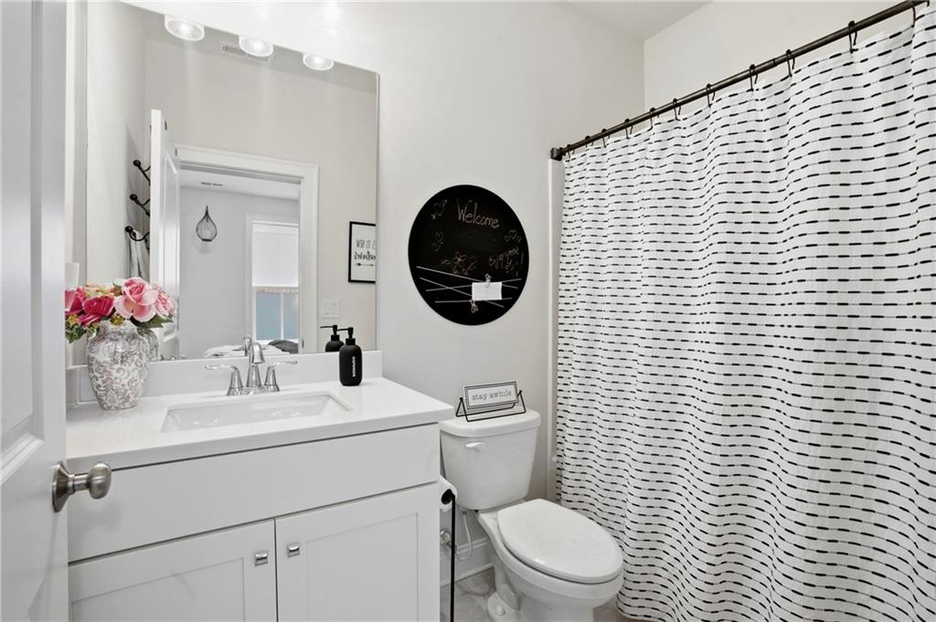3880 Pr Fld Crossing Suwanee, GA 30024 - Photo 35 of 51 a bathroom with a toilet a sink a mirror and a shower
