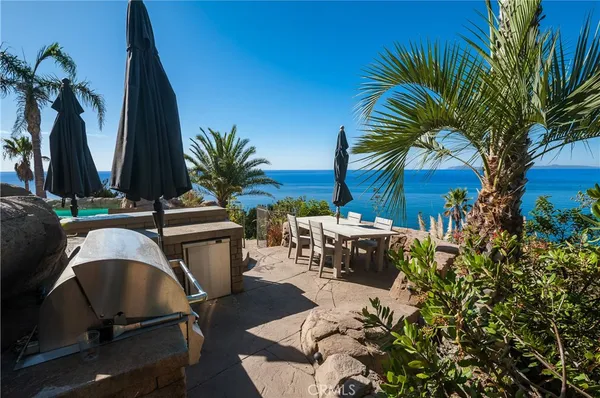 a backyard of a house with barbeque oven table and chairs