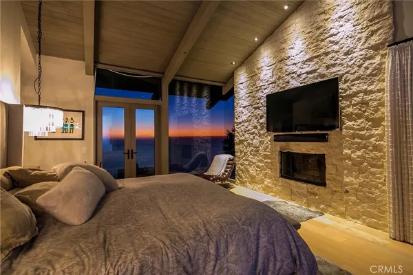 a spacious bedroom with a bed and a flat screen tv