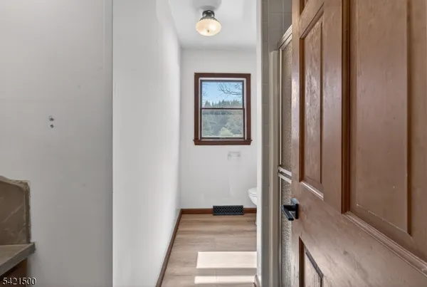 a view of a hallway with wooden floor and entryway
