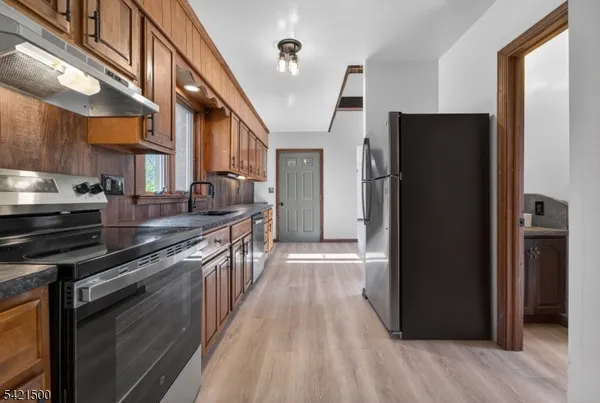a kitchen with stainless steel appliances granite countertop a refrigerator and a stove top oven