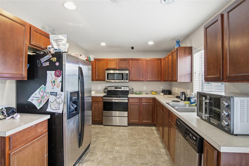 2463 Martins Run Tavares, FL 32778 - Photo 16 of 24 a kitchen with stainless steel appliances granite countertop a refrigerator stove microwave and sink