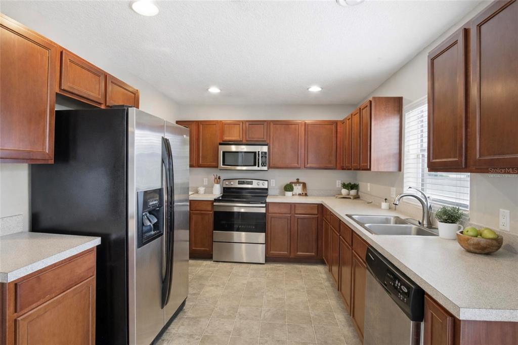 2463 Martins Run Tavares, FL 32778 - Photo 3 of 24 a kitchen with stainless steel appliances granite countertop a refrigerator stove microwave and sink