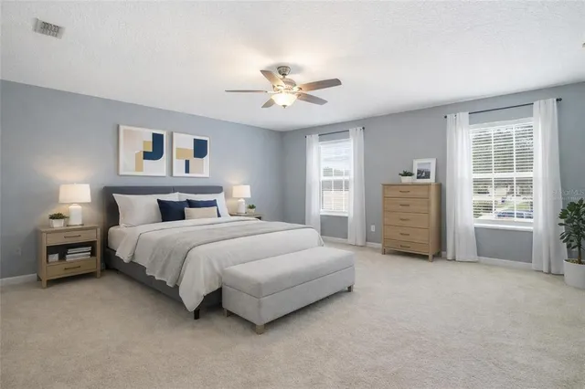 a spacious bedroom with a bed and a chandelier