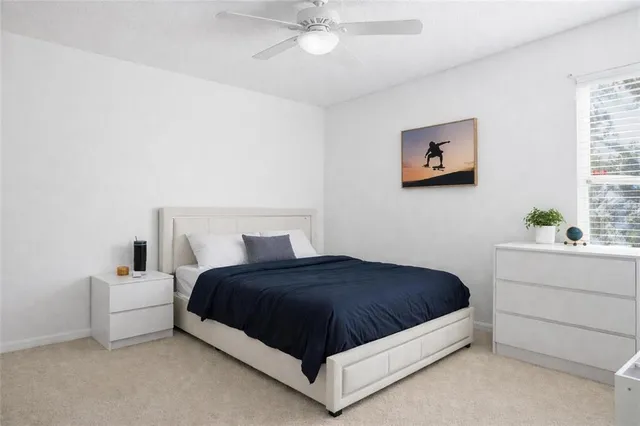 a bedroom with a bed lamp and paintings on the wall