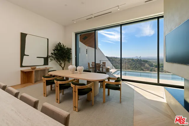 a open kitchen with a table chairs and flat screen tv