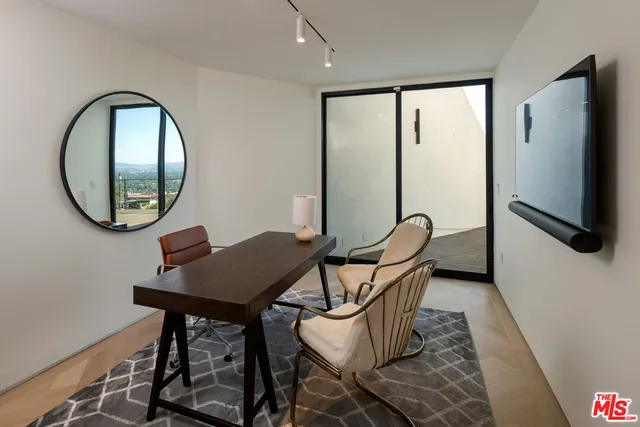 a view of a workspace room with furniture and wooden floor