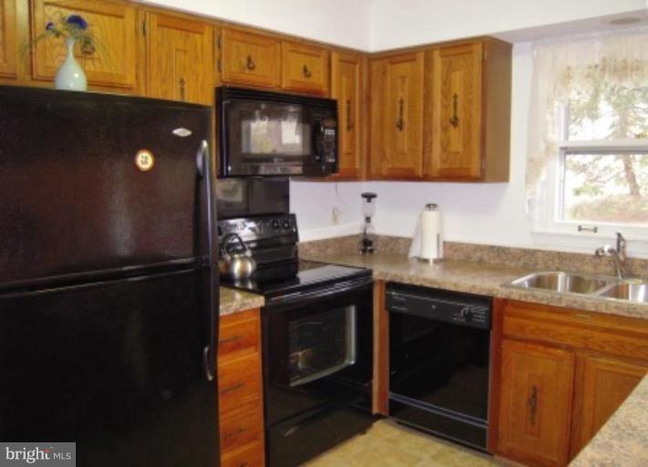 9155 Rockefeller Lane Springfield, VA 22153 - Photo 4 of 15 a kitchen with stainless steel appliances granite countertop a refrigerator stove and microwave