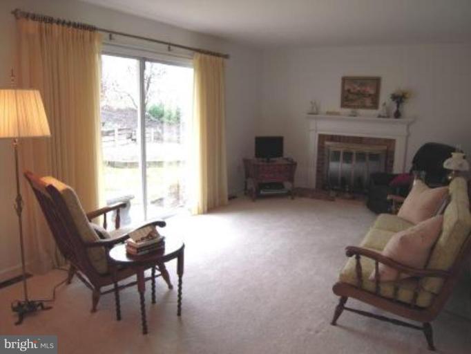 9155 Rockefeller Lane Springfield, VA 22153 - Photo 6 of 15 a living room with furniture a fireplace and a large window