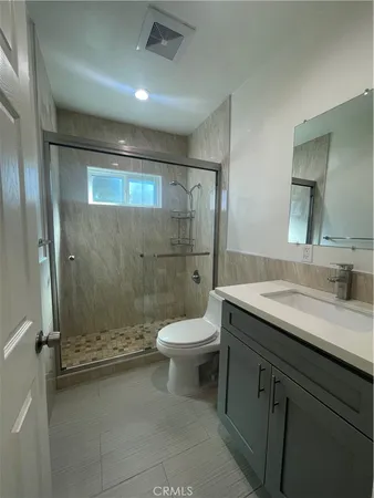 a bathroom with a granite countertop sink toilet and shower