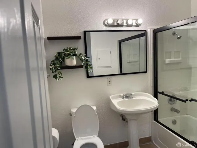 a bathroom with a toilet sink and mirror